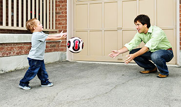 dad playing catch with his son for a kid-parent activity dad and son playing with a ball