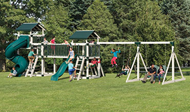 kids and parents playing on an adventure world playset family playing outside on swing set