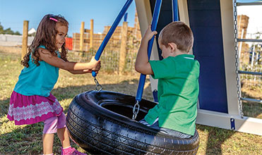 boy and girl playing on playset tire swing accessory  tire swing accessory on playset