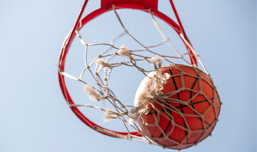 a girl on monkey bars being supervised by parents