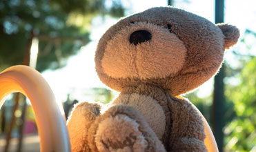 a girl climbing up a playground slide Teddy bear